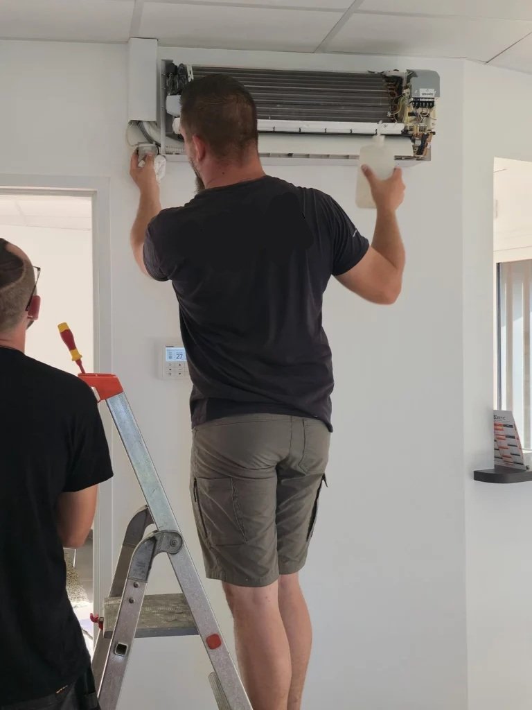 Entretien de climatisation en intérieur par un technicien d'intervention.